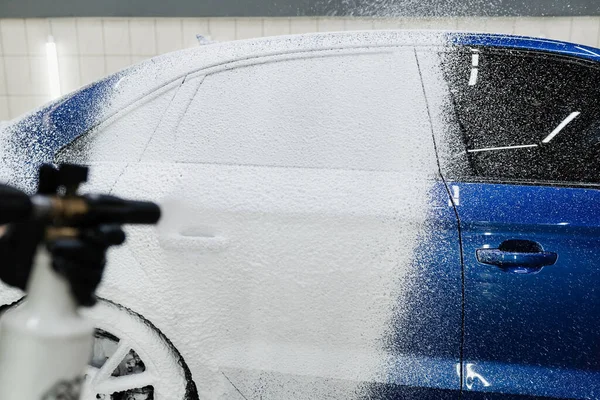 ガレージ内の車体に泡を噴霧するプロセス 車のサービスで洗濯の詳細の第二段階 車の洗濯機は完全なボディ車の洗浄を行う — ストック写真