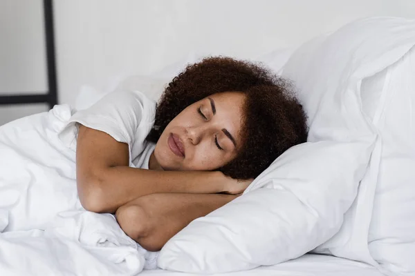 闭着眼睛的非洲女孩午睡时躺在舒适的床上 非洲裔美国女人醒来前放松一下 — 图库照片