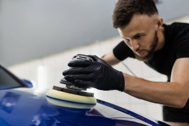 Yörünge cilasıyla cilalanan sert balmumu araba yakın plan çizikleri silmek için. Otomatik servisin detaylandırılmasında çalışma süreci