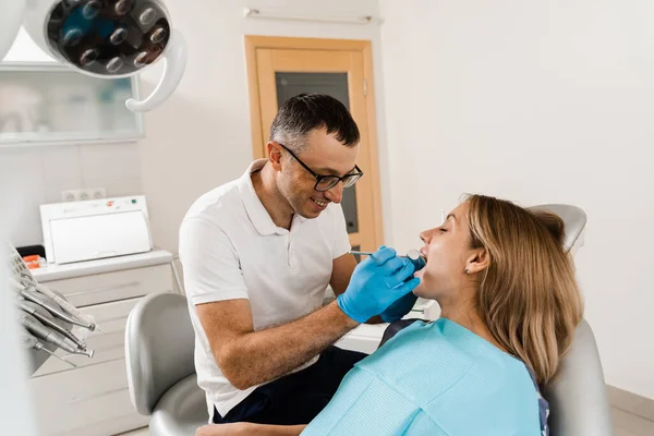 stock image Dentist examines teeth of woman for treatment of toothache. Pain in teeth. Consultation with dentist in dentistry