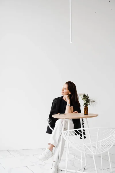 Stili Giyinmiş Hayalperest Neşeli Kız Beyaz Kafede Masada Oturuyor Beyaz — Stok fotoğraf