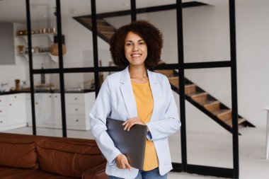 Dizüstü bilgisayarı olan kendine güvenen Afrikalı bir emlakçı. Kiralık ya da satın alınmış daireleri gösteriyor. Müşteriler için konut kredisi. Emlak ajansı için yaratıcı fotoğraf