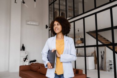 Dizüstü bilgisayarı olan kendine güvenen Afrikalı bir emlakçı. Kiralık ya da satın alınmış daireleri gösteriyor. Müşteriler için konut kredisi. Emlak ajansı için yaratıcı fotoğraf