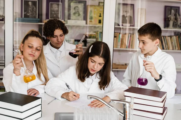 Schüler Beim Chemieunterricht Klassenzimmer Schüler Schreiben Notizbücher Halten Fläschchen Mit — Stockfoto