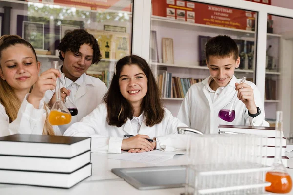 Školáci Studují Hodině Chemie Zorničky Píšou Zápisníku Drží Baňky Tekutinou — Stock fotografie