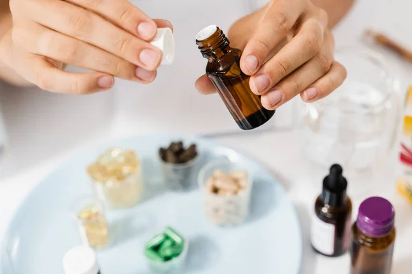 Face serum oil close-up in hands in gloves. Girl is holding face serum in hands for acne treatment and wrinkle smoothing