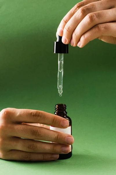 Pipette with Cannabidiol CBD oil in hand. CBD oil from the Cannabis plant to help reduce pain, anxiety, and sleep disorders