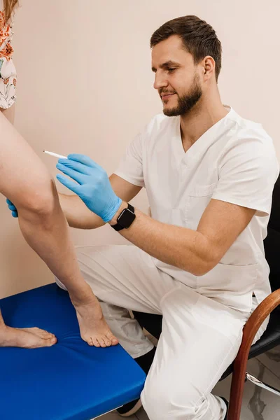 The vascular surgeon is marking leg veins. Vein markup. The phlebologist is marking legs before surgery to remove the veins