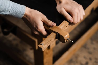 Craftsman is cutting the belt genuine leather using cutter in the workshop. Genuine leather belt creation process in production factory