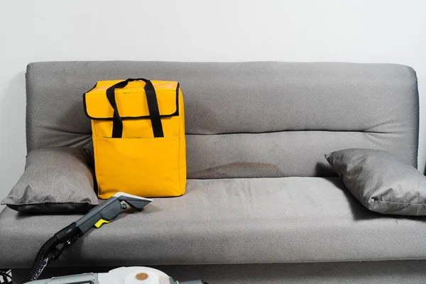 Professional dry cleaning machine and yellow transport bag. Extractor dry cleaning machine for removing stains and dirt from couch at home. Professional cleaning service