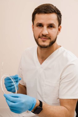 Vascular surgeon is holding EVLT Red laser optical fiber for endovenous laser coagulation for treatment varicose veins, thrombophlebitis, thrombosis