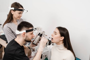 ENT doctor colleagues is spraying nitrogen for cryotherapy. Cryo procedures for mucosal renewal and treatment of chronic pharyngitis and tonsillitis. Otolaryngologist with cryosprayer