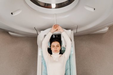 CT scan of abdominal of woman in medical clinic. Girl patient is doing computed tomography x-ray examination of abdominal in a CT scan room top view