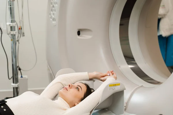Girl patient lies on computed tomography bed and scanning lungs for diagnose lung cancer in medical clinic. CT x-ray examination of lung cancer in medical clinic