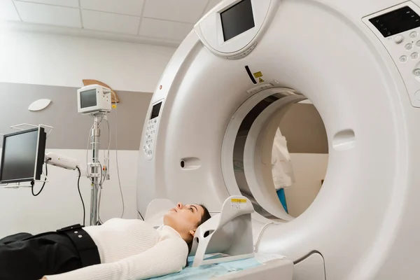 Girl patient is doing computed tomography x-ray examination of tumor in his head in a CT scan room. CT scan of brains of woman in medical clinic