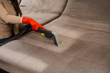 Domestic cleaning service cleaner is removing dirt and dust from couch using dry cleaning extraction machine. Line on couch after spraying water of dry cleaning extractor machine close-up