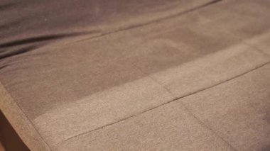 4k video housekeeper is extracting dirt from upholstered sofa using dry cleaning extractor machine. Cleaner girl is cleaning couch with extraction machine for dry clean upholstered furniture