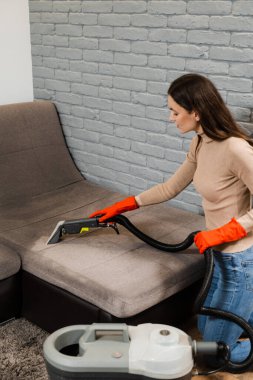 Domestic cleaning service cleaner is removing dirt and dust from couch using dry cleaning extraction machine. Line on couch after spraying water of dry cleaning extractor machine close-up