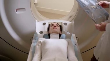 Tıbbi klinikte akciğer kanserinin 4k video tomografisi. Hasta kız bilgisayarlı tomografi yatağına uzanıp akciğer kanseri teşhisi için akciğerleri tarıyor..