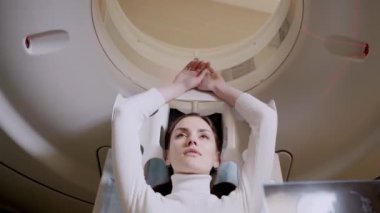 4k video CT scanning of abdomen of woman in medical clinic. Girl patient is doing CT computed tomography x-ray scan of chest for examination of abdomen in a CT scanning room