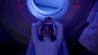 Klinikteki kadının karın tomografisi 4K video görüntüsü. Kız hasta bilgisayarlı tomografi yapıyor. Abdominal röntgen taraması yapıyor.
