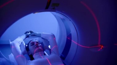 4k video CT scanning of abdomen of woman in medical clinic top view. Girl patient is doing CT computed tomography x-ray scan of chest for examination of abdomen in a CT scanning room.