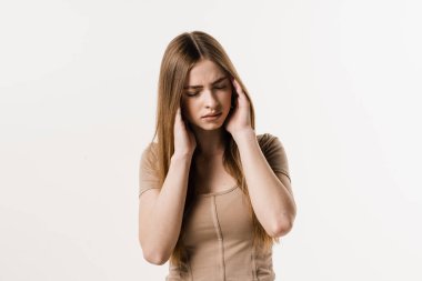 Migraine is a strong headache of girl isolated on white background. Overstressed young woman touches her head because of pain. Depression of attractive girl