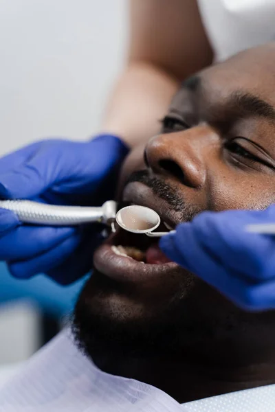 Dental drill close-up. Dentist drilling teeth of african man in dentistry clinic. Teeth treatment. Dental filling for african american man patient