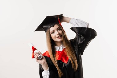 Gülümseyen ve diplomasını beyaz arka planda tutan mutlu mezun kız. Mezuniyet. Üniversiteden mezun olup yüksek lisans yapmış.