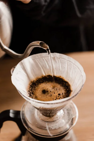 stock image Close-up pour over filter with ground coffee in the funnel in focus. Drip filter coffee brewing. Pour over alternative method of pouring water over roasted and ground coffee beans contained in filter