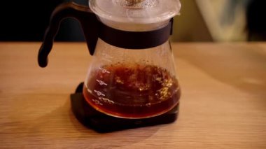 4k video filtre kahve alternatif demleme metodunun üzerine dökülüyor. Kavrulmuş sıcak su dökmek ve kağıt filtrede bulunan kahve çekirdekleri..