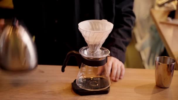 4Kビデオバリスタ紙フィルターにコーヒーを注ぎ ドリップケトルから水を注ぎます 淹れ方はカフェでフィルターコーヒーを注ぐ — ストック動画