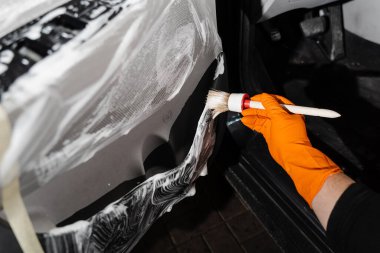 Araba kapısı paneli ile köpük ve deterjan temizleme işlemi. Araba temizleme servisi. Müşterilerin iç çamaşırlarını yıkayan temizlik işçisi