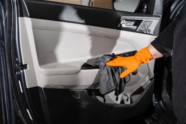 Otomobil servisinde mikrofiber kullanarak araba kapısının içini kurutan el arabası. Temizlikçi, kuru araba.