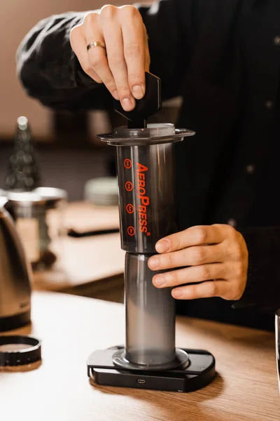 Barista brews Aeropress coffee and stirs it inside. Process of aeropress alternative method brewing coffee