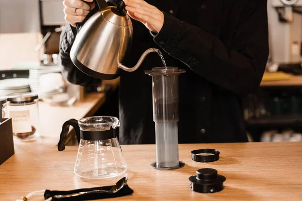 将热水倒在烤好的咖啡豆上 然后用飞机压碎 空压机替代酿制咖啡的工艺 Barista正在咖啡店里煮空姐咖啡 — 图库照片