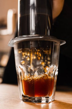 Uçak kahvesi. Bardağa kahve doldurma işlemi. Barista kahve damlaları için uçağı zorluyor. Düşen kahve damlaları yakın planda.