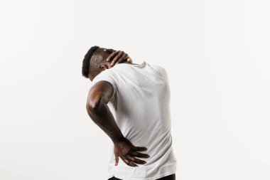 Afrikalı adam, beyaz arka planda omurga ve boyun ağrısı hissediyor. Servikal omurga osteokondrosis Afro-Amerikan erkeklerinin radikal sendromlarıdır.