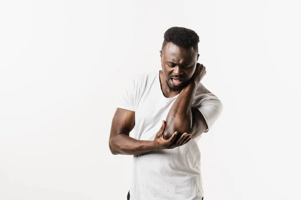 stock image Elbow injury of african american man on white background. Traumatology. African american man with pain and bruise in his arm due to an accident