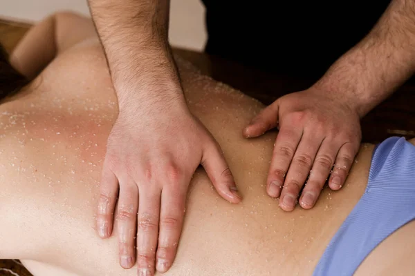 Masażysta Wykonuje Relaksujący Masaż Przy Użyciu Peelingu Solnego Salonie Spa — Zdjęcie stockowe