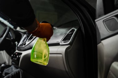 Arabanın iç tarafındaki hava sistemine kuru temizleme için deterjan sıkıyorum. Profesyonel eldiven temizleyicisi, arabanın hava sistemine leke ve kiri temizlemek için deterjan döküyor.