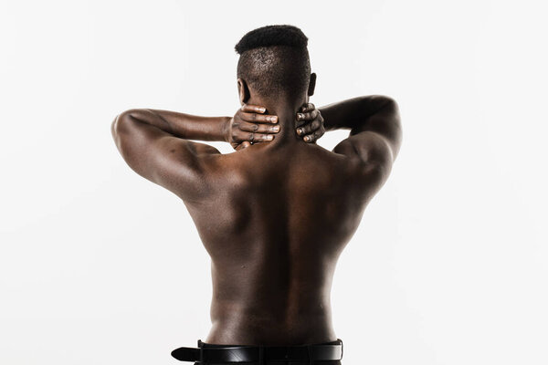 Rheumatism and arthritis diseases. Rachiocampsis bachache and neck pain of shirtless african man on white background. Scoliosis is sideways curvature of the spine of muscular african american man
