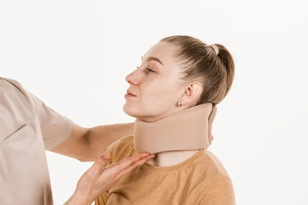 创伤专家给年轻女性戴上颈椎软领或颈圈绷带 以支撑和固定颈部或治疗创伤性头部或颈部损伤 — 图库照片