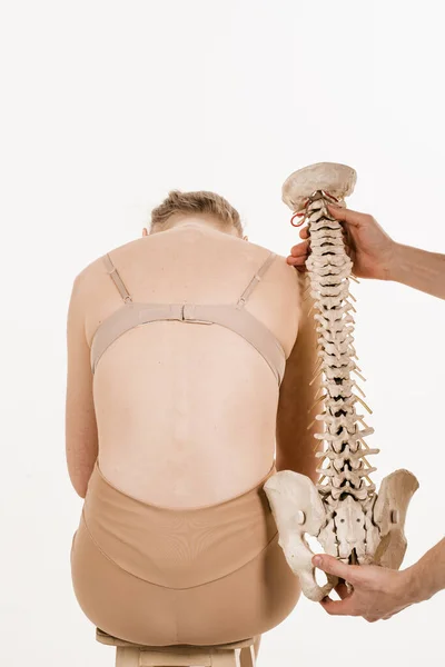 脊柱侧弯是脊柱侧弯 后骨解剖模型与年轻女子 有白人背景的女孩的脊柱模型的矫形外科医生 — 图库照片
