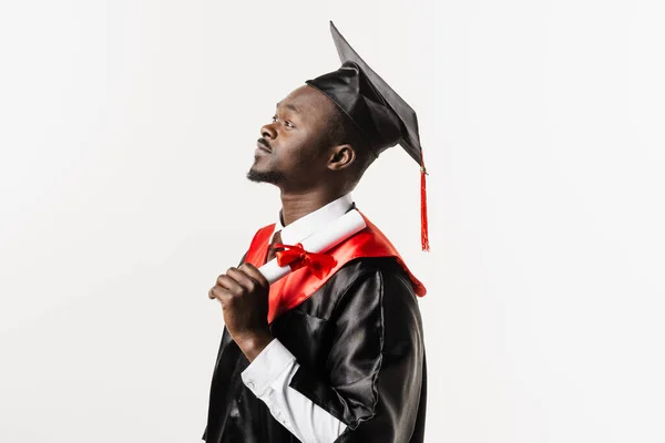 Graduate african man with master degree in black graduation gown and cap on white background. Happy african student successfully graduated from the university with honors