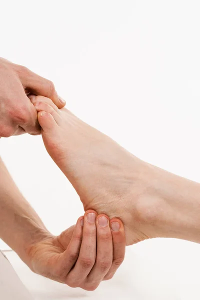 足を閉じる 整形外科医は 生理学的運動の量の評価のために触れて 足を押しています 足首や足の動きの検査 — ストック写真