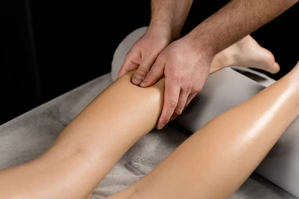 Foot and legs massage in spa. Masseur making foot and legs massage with massage oil. Relaxation