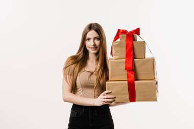 Beyaz arka planda hediye kutularını tutan mutlu, genç bir kadın. Doğum gününde ya da diğer tatillerde kutlama ve hediye alma
