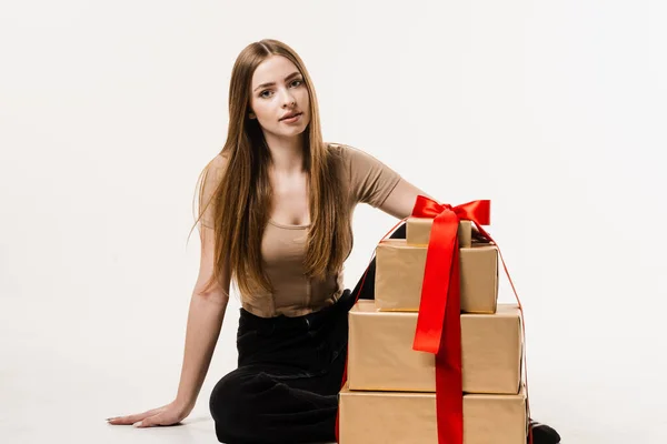 Event celebration and receiving gift on birthday or other holiday. Happy pretty young woman holding gift boxes with present on white background