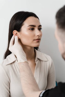 Kulak ameliyatı. Kulak ve Pinna cerrahi yeniden şekillendirme. Doktor otoplasti estetik ameliyatından önce kız kulaklarını muayene ediyor.